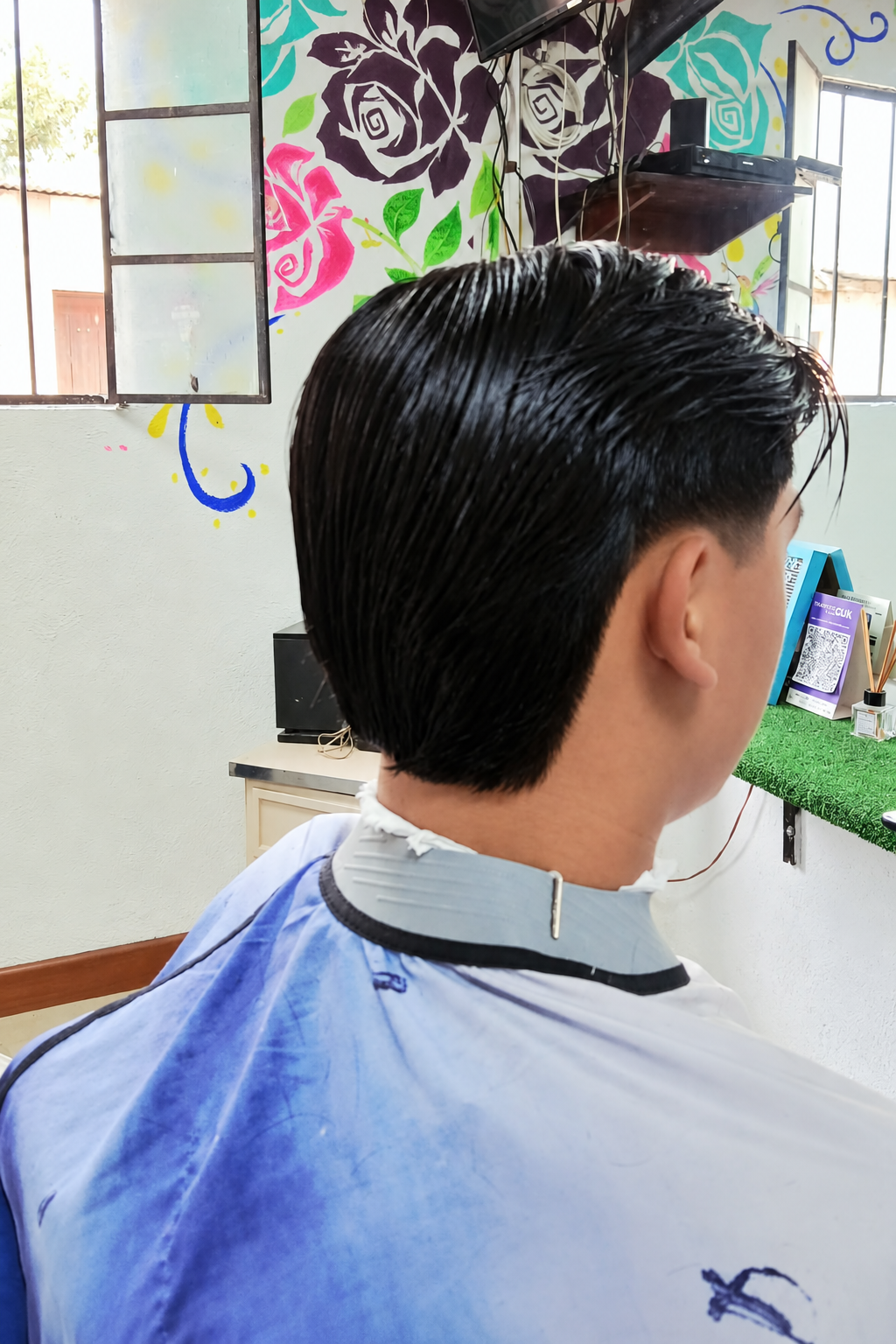 Corte clásico con degradado y cabello peinado hacia atrás realizado en Rocky&Chely